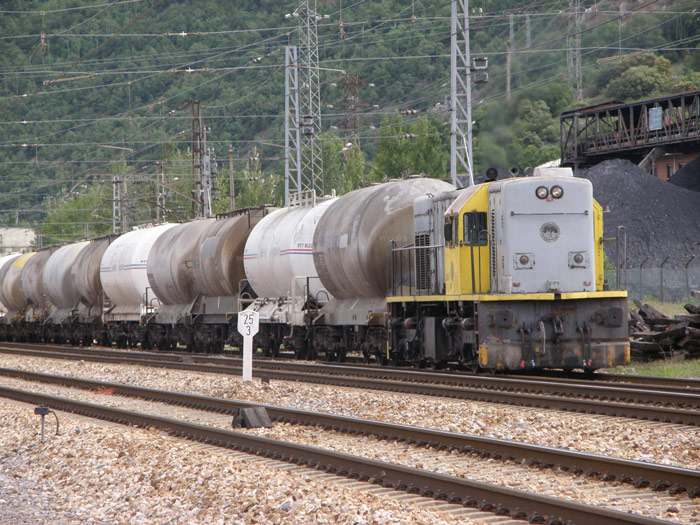 Una composici�n de cisternas de cementos, remolcado por una locomotora de la cementera, encamina el tren por las v�as de La Robla desde un cargadero